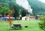 The railroad station is adjacent to the campground. The engine blows off steam as part of its morning preparations.